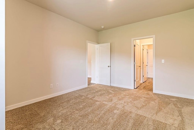 unfurnished bedroom with baseboards and light colored carpet