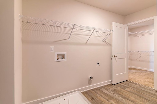 clothes washing area with hookup for a washing machine, laundry area, wood finished floors, baseboards, and electric dryer hookup