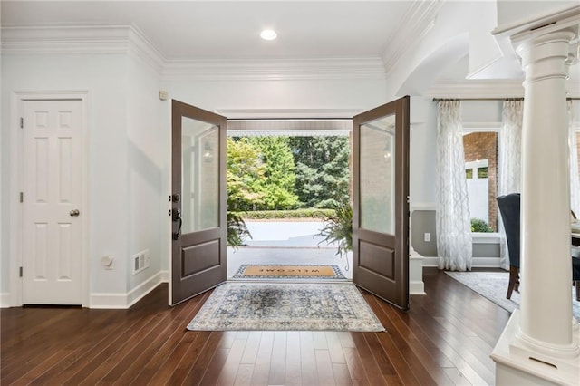 foyer featuring plenty of natural light, dark hardwood / wood-style flooring, and ornate columns