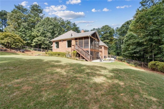 rear view of house with a lawn and a sunroom