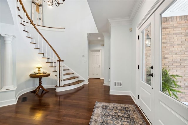 entrance foyer with dark wood-type flooring, decorative columns, and crown molding