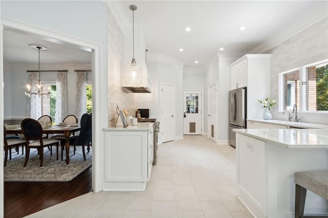 kitchen with plenty of natural light, hanging light fixtures, stainless steel appliances, and light hardwood / wood-style flooring