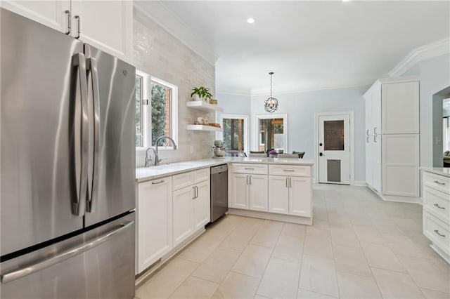 kitchen featuring ornamental molding, stainless steel appliances, kitchen peninsula, sink, and white cabinets