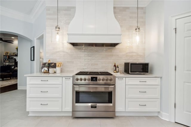 kitchen featuring crown molding, custom range hood, stainless steel appliances, and white cabinets