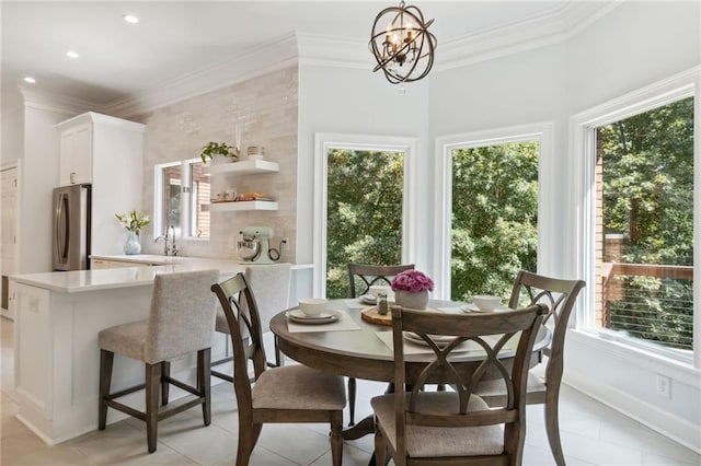 tiled dining area with crown molding, sink, and a chandelier