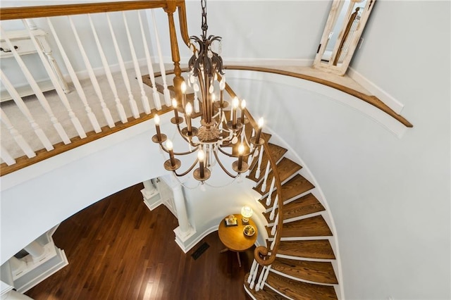 stairs with a chandelier and hardwood / wood-style floors