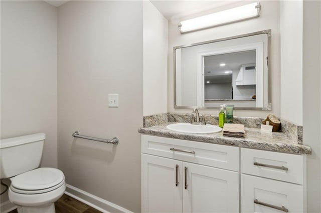 bathroom featuring vanity, toilet, and hardwood / wood-style flooring