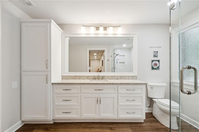 bathroom featuring vanity, toilet, hardwood / wood-style floors, and walk in shower