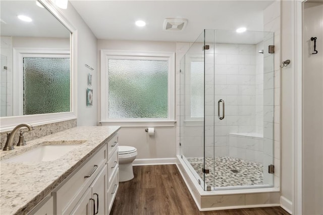 bathroom with vanity, toilet, hardwood / wood-style flooring, and a shower with shower door