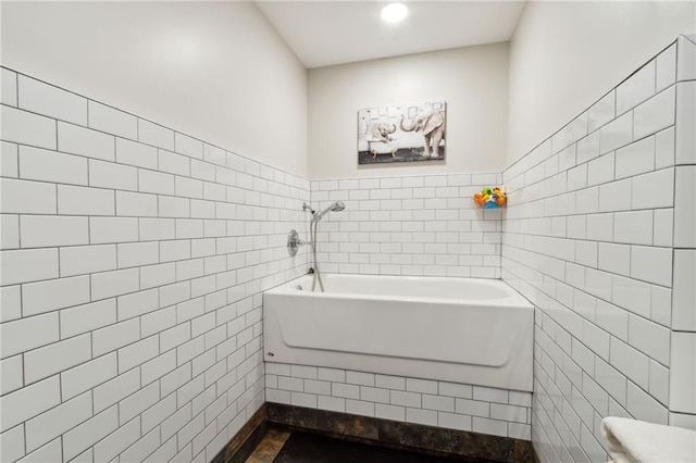 bathroom with tile walls, toilet, and  shower combination