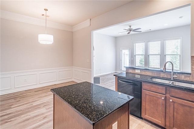 kitchen featuring sink, decorative light fixtures, black dishwasher, light hardwood / wood-style floors, and a kitchen island