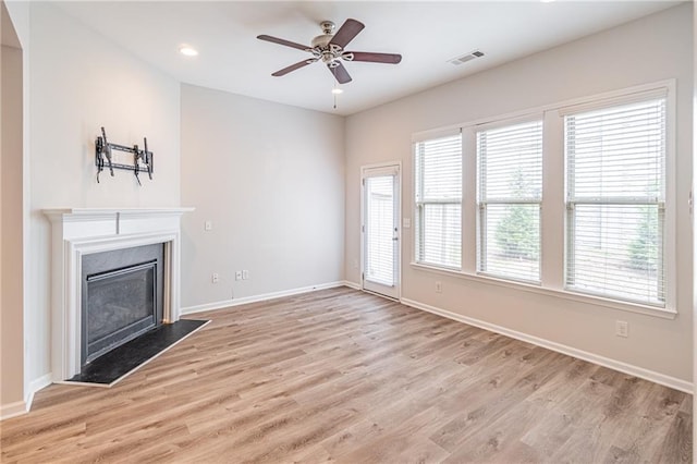 unfurnished living room featuring ceiling fan and light hardwood / wood-style flooring