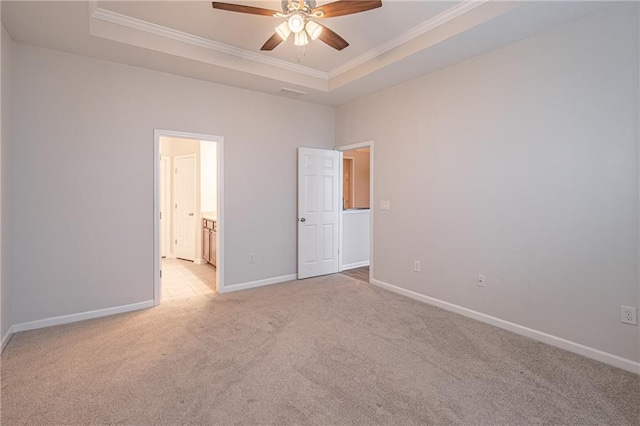 unfurnished bedroom with ceiling fan, a raised ceiling, crown molding, and light carpet