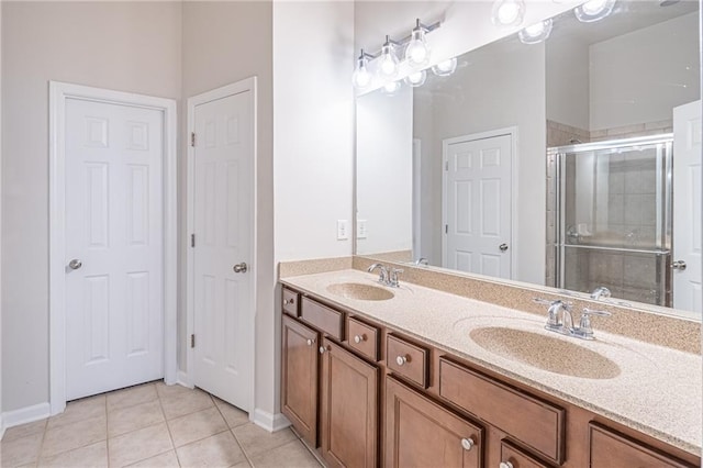 bathroom with tile patterned flooring, vanity, and walk in shower