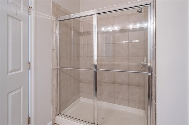 bathroom featuring a shower with door