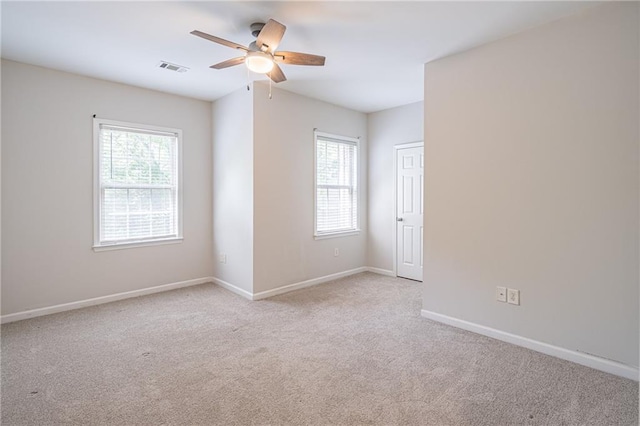 empty room featuring light carpet, plenty of natural light, and ceiling fan