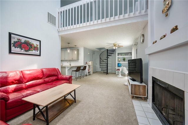 2507 Albion Farm Way, Duluth, GA 30097 - living room with a tile fireplace, a towering ceiling, light carpet, a ceiling fan, and stairway