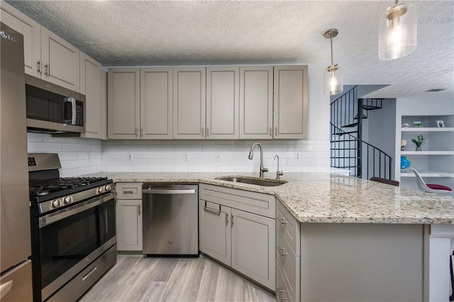 2507 Albion Farm Way, Duluth, GA 30097 - kitchen featuring appliances with stainless steel finishes, gray cabinets, a sink, a textured ceiling, and a peninsula