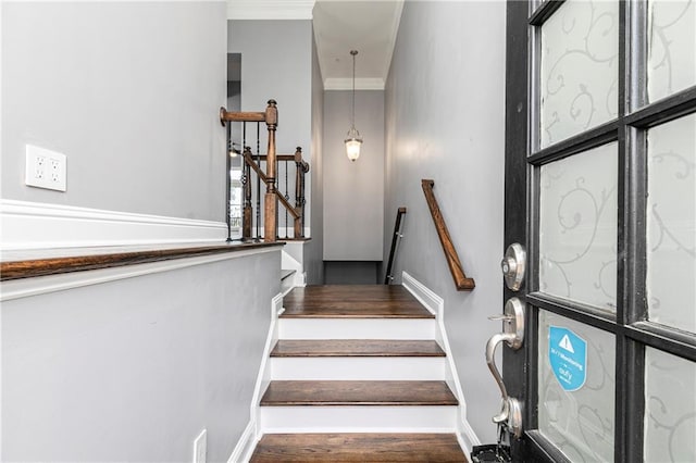 stairs with hardwood / wood-style flooring and ornamental molding