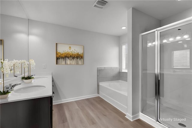 bathroom with a garden tub, wood finished floors, a sink, visible vents, and a shower stall