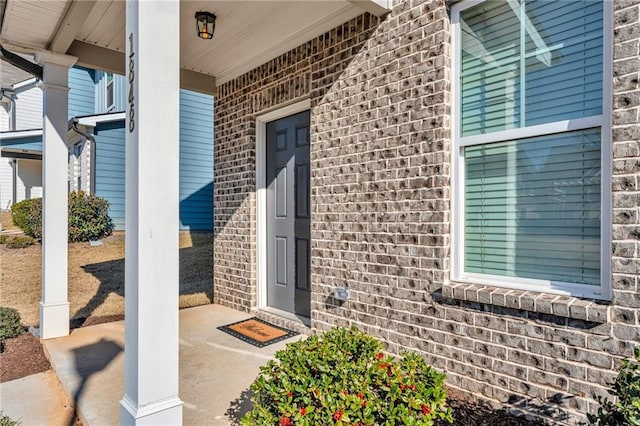 entrance to property featuring brick siding