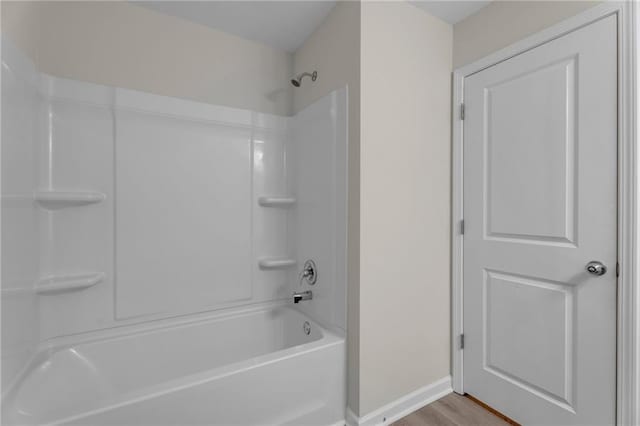 full bathroom featuring baseboards and wood finished floors