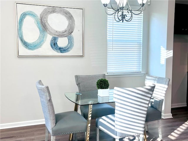 dining area featuring a chandelier, baseboards, and wood finished floors