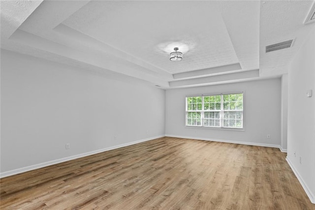 1897 Alcovy Trace Way, Lawrenceville, GA 30045 - empty room with a raised ceiling, light wood finished floors, baseboards, and a textured ceiling