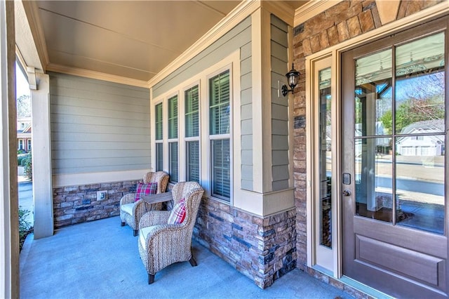 entrance to property with a porch and stone siding