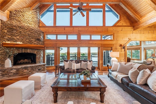 living area with ceiling fan, beam ceiling, high vaulted ceiling, and wooden ceiling