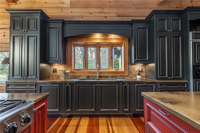 kitchen featuring backsplash, dark countertops, a wealth of natural light, and a sink