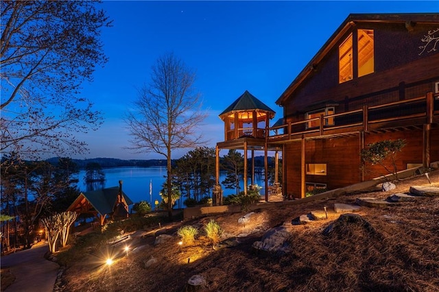 exterior space featuring a fire pit and a deck with water view
