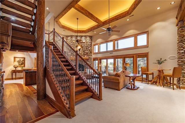 stairway featuring coffered ceiling, a towering ceiling, baseboards, and recessed lighting