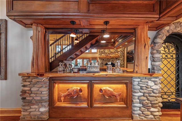 bar with pendant lighting, crown molding, and indoor bar
