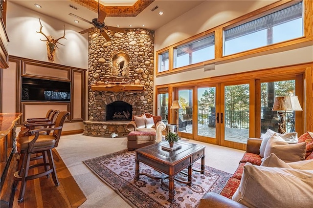 living area featuring carpet, a ceiling fan, a high ceiling, and recessed lighting