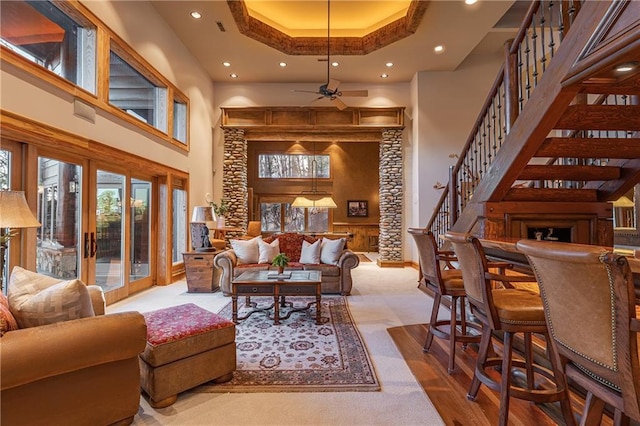 living room featuring a ceiling fan, recessed lighting, a high ceiling, stairway, and carpet floors
