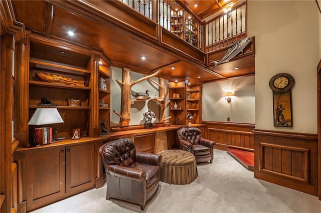 interior space featuring a wainscoted wall, built in features, wood walls, and carpet floors