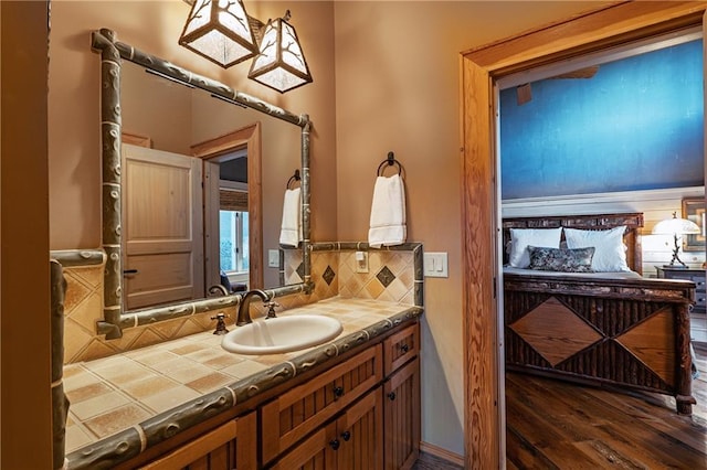 bathroom featuring vanity, decorative backsplash, and wood finished floors
