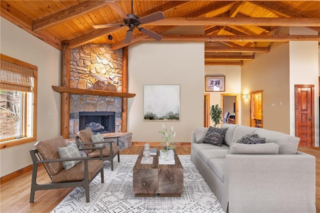 living area with a fireplace, light wood finished floors, wood ceiling, and ceiling fan