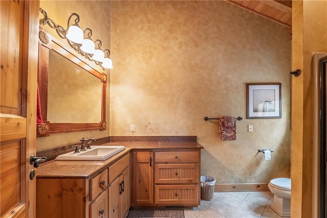 bathroom featuring tile patterned flooring, toilet, baseboards, and vanity