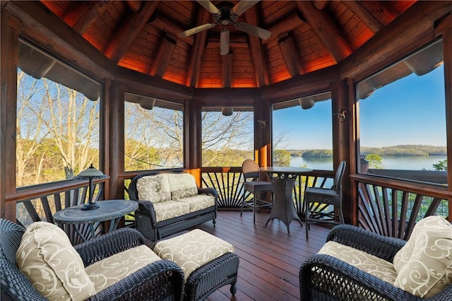 sunroom featuring a water view, a ceiling fan, and beamed ceiling