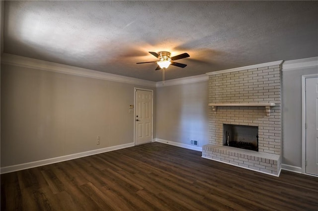 unfurnished living room featuring ceiling fan, a textured ceiling, a brick fireplace, ornamental molding, and dark hardwood / wood-style floors