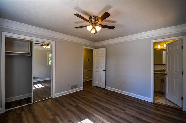 unfurnished bedroom featuring crown molding, ceiling fan, a closet, and dark hardwood / wood-style flooring