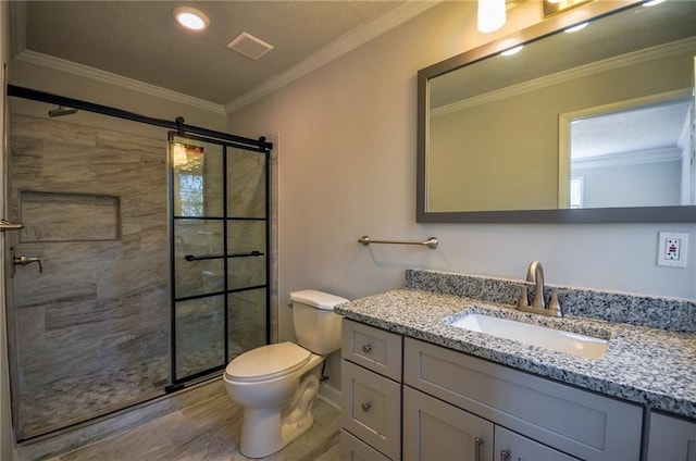 bathroom featuring vanity, toilet, ornamental molding, and a shower with shower door