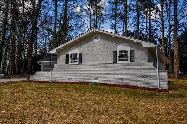 view of side of home with a yard