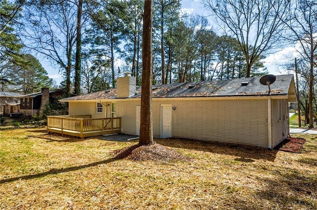rear view of house featuring a yard and a deck