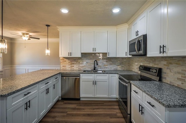 kitchen with sink, white cabinetry, hanging light fixtures, and stainless steel appliances