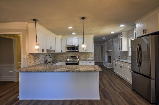 kitchen with dark hardwood / wood-style floors, white cabinets, stainless steel appliances, and hanging light fixtures