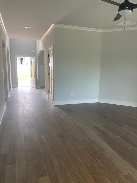 129 Silvercrest Dr, Acworth, GA 30101 - unfurnished room featuring arched walkways, ceiling fan, ornamental molding, dark wood finished floors, and baseboards
