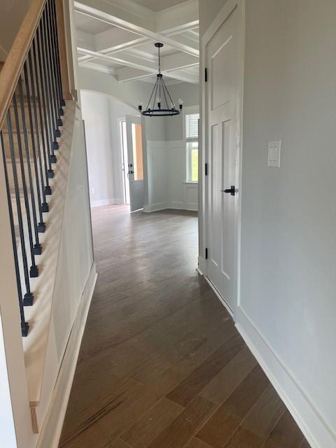 129 Silvercrest Dr, Acworth, GA 30101 - hallway with coffered ceiling, a chandelier, beamed ceiling, wood finished floors, and stairway